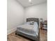 Clean and minimalist bedroom with a gray upholstered bed frame, wood floors, and a bookshelf with neatly arranged items at 1543 Withers Dr, Denver, NC 28037