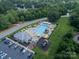 Aerial view of a community pool, clubhouse, playground, and parking area, surrounded by lush greenery and umbrellas at 1543 Withers Dr, Denver, NC 28037