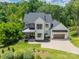 Aerial view of a modern farmhouse with manicured lawn, mature trees, and inviting curb appeal at 1543 Withers Dr, Denver, NC 28037