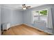 Bedroom featuring hardwood floors, a ceiling fan, and a window with white curtains at 173 Riverwood Rd, Mooresville, NC 28117