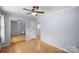 Bedroom with hardwood floors, ceiling fan, and closet with mirrored doors at 173 Riverwood Rd, Mooresville, NC 28117