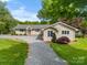 Home exterior features a gravel driveway, lush lawn, and mature landscaping at 173 Riverwood Rd, Mooresville, NC 28117