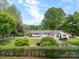 Charming single-story home featuring mature trees, lush lawn, and a welcoming front entrance at 173 Riverwood Rd, Mooresville, NC 28117