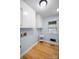 Laundry room with white cabinets, hardwood floors, and a lake view from the window at 173 Riverwood Rd, Mooresville, NC 28117
