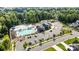Aerial view showcases a community clubhouse, pool, parking, and surrounding green spaces and residential areas at 1908 Masons Bend Dr, Fort Mill, SC 29708