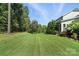 Large, grassy backyard surrounded by lush trees and beautiful landscaping at 1908 Masons Bend Dr, Fort Mill, SC 29708