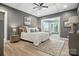 Bedroom featuring light wood floors, a white bed with pillows, and an adjacent sunroom at 1908 Masons Bend Dr, Fort Mill, SC 29708