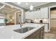 Kitchen island with stainless steel sink, white countertop, and view of the white cabinets at 1908 Masons Bend Dr, Fort Mill, SC 29708