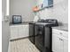 Laundry room with modern washer and dryer units, cabinets, and overhead storage at 1908 Masons Bend Dr, Fort Mill, SC 29708