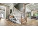 Open staircase with wood flooring, white risers, and views of the open-concept living space at 1908 Masons Bend Dr, Fort Mill, SC 29708