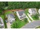 An aerial view captures a house with its well-maintained lawn, driveway, and adjacent homes, set against a backdrop of lush trees at 231 Anvil Draw Pl, Rock Hill, SC 29730