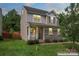 Charming two-story home with stone accents, a cozy front porch, and a well-maintained lawn at 231 Anvil Draw Pl, Rock Hill, SC 29730