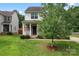 Charming two-story home with stone accents, a cozy front porch, and a well-maintained lawn at 231 Anvil Draw Pl, Rock Hill, SC 29730