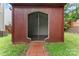 Outdoor screened building with wood-paneled walls and shelves with brick path access in backyard at 231 Anvil Draw Pl, Rock Hill, SC 29730