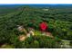 An aerial view of houses amongst a luscious green tree line with a location pin at 236 Mark Ryan Ln, Dallas, NC 28034