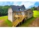Exterior rear view featuring a spacious deck and stairs leading to the landscaped yard at 236 Mark Ryan Ln, Dallas, NC 28034