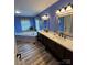 Bathroom featuring double sinks, a bathtub, and blue walls at 250 Wesley Amaker Rd, York, SC 29745