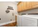 Convenient laundry room with washer, dryer, and upper cabinets for ample storage at 254 Charter Se Ct, Concord, NC 28025