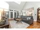 Comfortable living room featuring a large gray couch, skylights, and open access to the kitchen at 254 Charter Se Ct, Concord, NC 28025