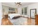 A well-lit main bedroom featuring hardwood floors, neutral paint, a ceiling fan, and modern decorations at 254 Charter Se Ct, Concord, NC 28025