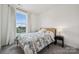 Bright bedroom featuring a patterned bedspread, neutral walls, and a large window at 4148 Alexander View Dr, Charlotte, NC 28226