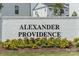 Alexander Providence entrance sign with black text on a white brick wall surrounded by flowers at 4148 Alexander View Dr, Charlotte, NC 28226