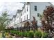 Street view of white townhomes with black accents and professionally landscaped front yards at 4148 Alexander View Dr, Charlotte, NC 28226