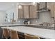 Close-up of kitchen featuring gray backsplash, stainless steel range hood, white countertops, and pendant lighting at 4148 Alexander View Dr, Charlotte, NC 28226