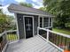 Charming exterior view of a home addition featuring an outdoor deck with black metal railings and a black front door at 4221 Hounds Run Dr, Matthews, NC 28105