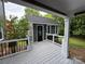 Charming exterior view of a home addition featuring an outdoor deck with black metal railings and a black front door at 4221 Hounds Run Dr, Matthews, NC 28105