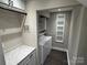 Well-equipped laundry room featuring modern washer and dryer, storage cabinet, and convenient shelving at 4221 Hounds Run Dr, Matthews, NC 28105