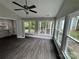 Bright sun room featuring hardwood floors, multiple windows, and a ceiling fan for year-round comfort at 4221 Hounds Run Dr, Matthews, NC 28105