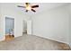 Bright bedroom featuring a ceiling fan, carpet floors, and walk-in closet at 448 River Park Rd, Belmont, NC 28012