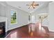 Spacious living room features a fireplace, ceiling fan, large windows, and rich hardwood floors at 448 River Park Rd, Belmont, NC 28012