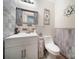Charming half bathroom with decorative mirror, accent tiles, white vanity and a comfort-height toilet at 4592 Reid Rd, Edgemoor, SC 29712