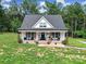 Charming home featuring a welcoming front porch with chairs and lovely landscaping at 4592 Reid Rd, Edgemoor, SC 29712