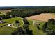 Aerial view of two homes with sprawling green lawns and a neighboring field, surrounded by dense trees at 4713 White Store Rd, Wingate, NC 28174