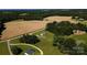Aerial view showcases house among trees and golden fields, merging comfort with nature at 4713 White Store Rd, Wingate, NC 28174