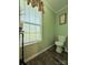Small bathroom with wood look flooring, light green walls, and a toilet at 4713 White Store Rd, Wingate, NC 28174