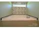 Stylish bathtub with marble-like backsplash and trim, set against decorative floral wallpaper and light green walls at 4713 White Store Rd, Wingate, NC 28174