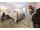Charming bedroom with pink walls, a wrought iron bed, and area rug at 4713 White Store Rd, Wingate, NC 28174