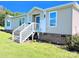 Charming manufactured home featuring a covered entry with white stairs and light beige siding on a sunny day at 4713 White Store Rd, Wingate, NC 28174