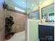 Modern tile shower with glass door, contrasting dark vanity and green walls at 4713 White Store Rd, Wingate, NC 28174
