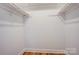 A closet with white walls and wooden floors, featuring shelves and a clothing rod for efficient organization at 4806 Spring Lake Dr # D, Charlotte, NC 28212