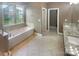 Elegant bathroom with a soaking tub, separate shower, dual vanity with granite countertops, and tile flooring at 5003 Tremont Dr, Indian Trail, NC 28079
