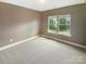 Bedroom with neutral walls and carpet; a bright window looks out onto green lawns and homes at 5003 Tremont Dr, Indian Trail, NC 28079