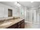 Bathroom features double sink vanity with granite counters, a large mirror, and tiled shower at 5069 Thomasville Dr, Belmont, NC 28012