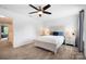 This bedroom offers natural light, carpet, ceiling fan, and a large bed with side tables at 5069 Thomasville Dr, Belmont, NC 28012