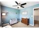 This bedroom offers natural light with blue walls, carpet, ceiling fan, and furnishings at 5069 Thomasville Dr, Belmont, NC 28012