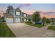 Charming two-story home with a two-car garage and a well-manicured lawn at dusk at 5069 Thomasville Dr, Belmont, NC 28012